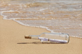 Message in a bottle lying on the beach
