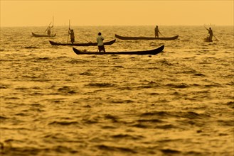 Fishermen in their boats at sunrise