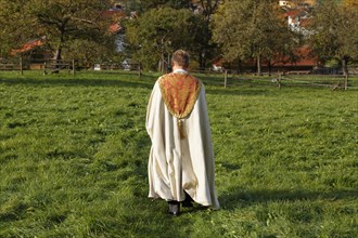 Pastor walking across a meadow