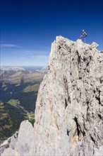 Climber on the summit of Cima Vezzena Mountain in the Pala Group