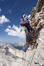 Mountain climber ascending the Via Ferrata Ivano Dibona climbing route on Monte Cristallo