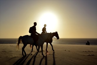 Two riders on horseback on the beach