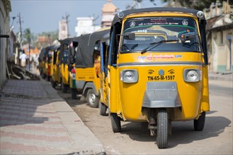 Row of yellow rickshaw taxis