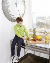 Young boy sitting on a kitchen worktop