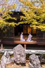 Two Japanese women dressed with kimono sitting in the courtyard of O-shoin