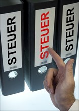 Hand pointing to file folders labeled 'Steuer'