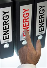 Hand pointing to a ring binder labeled Energy