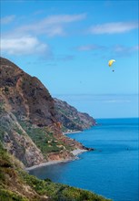 Cliff coast near Calheta with paragliders