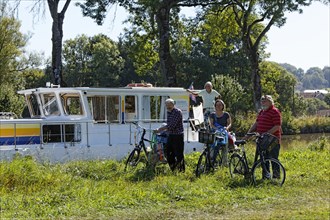 Holidaymakers in front of a house boat on the Canal des Vosges