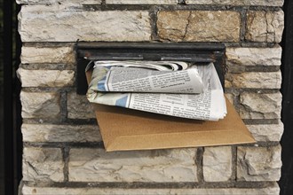 Full letter box of a house in a wall