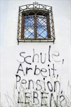 Graffiti under a barred window of a castle wall 'Schule