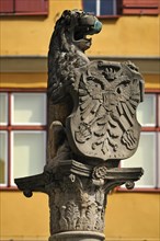 Lion sculpture holding a shield with the double-headed eagle at Loewenbrunnen