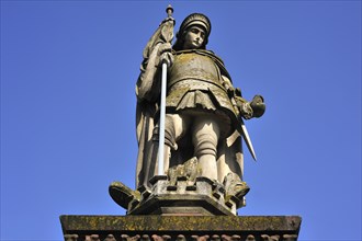 Sandstone statue of St. Florian against a blue sky