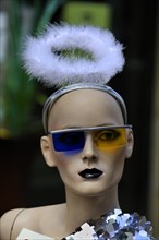 Mannequin with a feathers halo and sunglasses with different color glasses