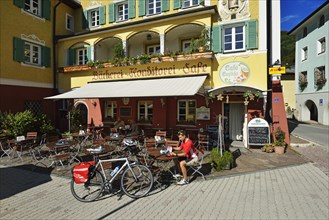 Cyclist having a break outside Cafe Cupido in Marktschellenberg