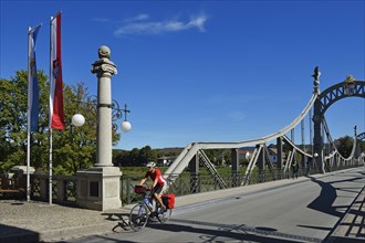 Cyclist crossing Laenderbruecke bridge between Bavaria and Salzburger Land