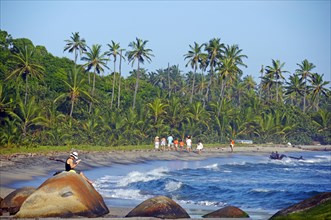 People walking along a sandy beach