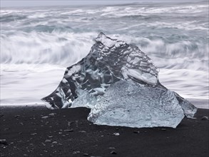 Chunk of ice lying on the black sandy lava beach on the edge of the Vatnajokull Glacier