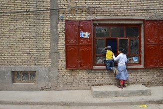 Uighur Muslim children in front of a basic store