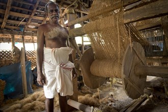 Man making ropes from coconut fibres in a small business