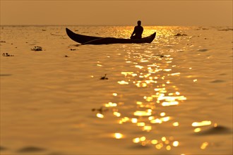 Fisherman in his boat at sunrise