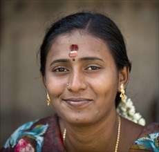 Woman with bindi on her forehead wearing gold ear rings