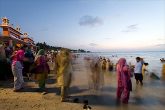 Hindu pilgrims taking a holy bath in the sea before sunrise