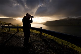 Silhouette of a photographer standing in front of dramatic