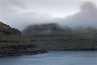 Low hanging clouds over a fjord