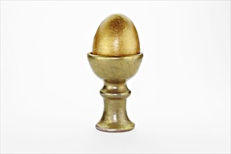 Golden egg in an egg cup