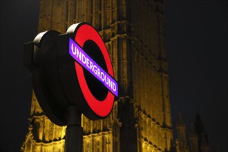 Sign of Westminster Underground Station in front of Elizabeth Tower or Big Ben at night