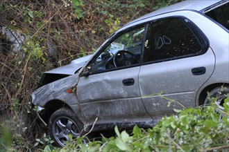 Car which has driven off the road and down an embankment