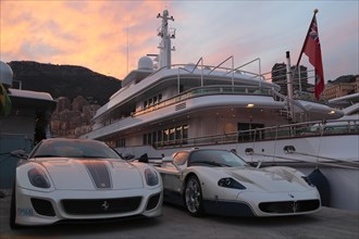 Maserati and Ferrari in front of the motoryacht 'Siran' in Port Hercule at twilight