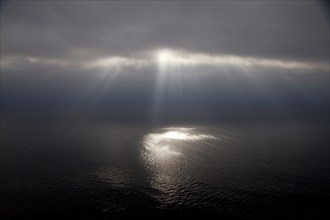 Dark clouds and sun rays over the Pacific Ocean