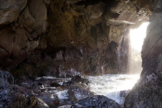 Surf and a ray of light on the rocky coast of Pfeiffer Beach