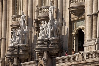 Statues and a balcony with visitors on the facade of the Gran Teatro de La Habana theater