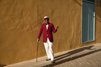 Actor Pedro Pablo Perez wearing a red suit with a hat and a cigar