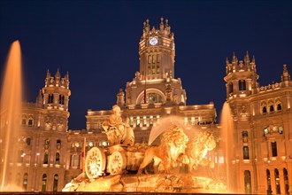 Illuminated Fuente de Cibeles fountain in front of the Palacio de Comunicaciones