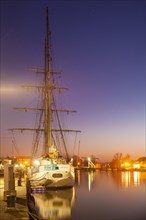 Sailing ship in the fishing port at dusk