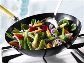 Stirfry vegetables being cooked in a wok