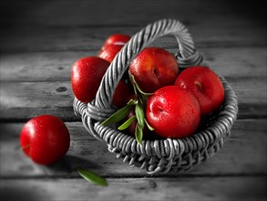 Fresh red plums in a basket