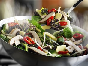 Stir-fry vegetables in a wok