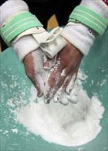 Gymnast rubbing chalk onto the palms of the hands