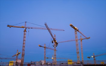 Construction cranes on the construction site of the Milaneo at dusk