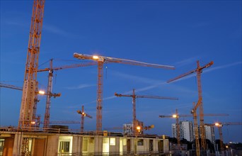 Construction cranes on the construction site of the Milaneo at dusk