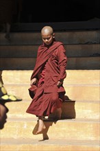 Young Buddhist monk stepping out of a monastery