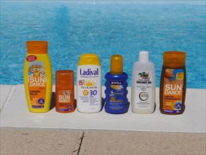 Various sunscreen products at a swimming pool