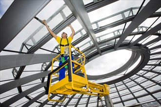 Window cleaner cleaning the glass panels of the dome of the Reichstag building