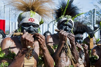 Members of a tribe in colourfully decorated costumes with face paint at the traditional sing-sing gathering