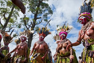 Women in colourfully decorated costumes with face paint at the traditional sing-sing gathering